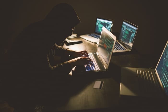 hacker working on multiple computers